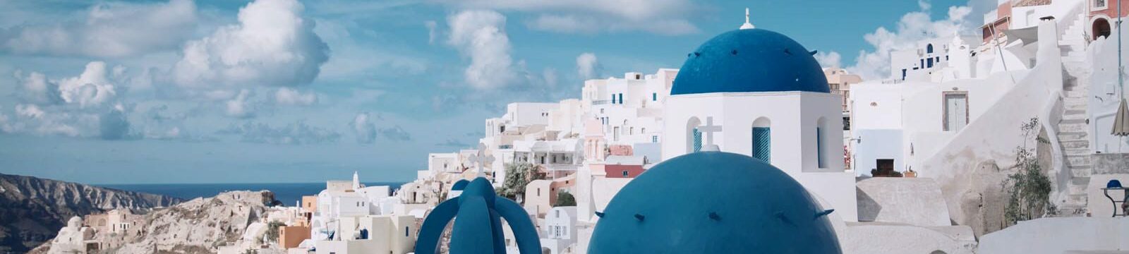Whitewashed buildings with iconic blue domed roofs in Santorini, Greece overlooking the sea