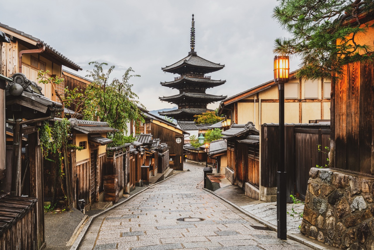 Historic Japanese street with wooden buildings and pagoda temple in background