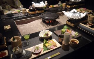 Japanese kaiseki dinner with sushi, sashimi, and hot plate cooking at a ryokan table