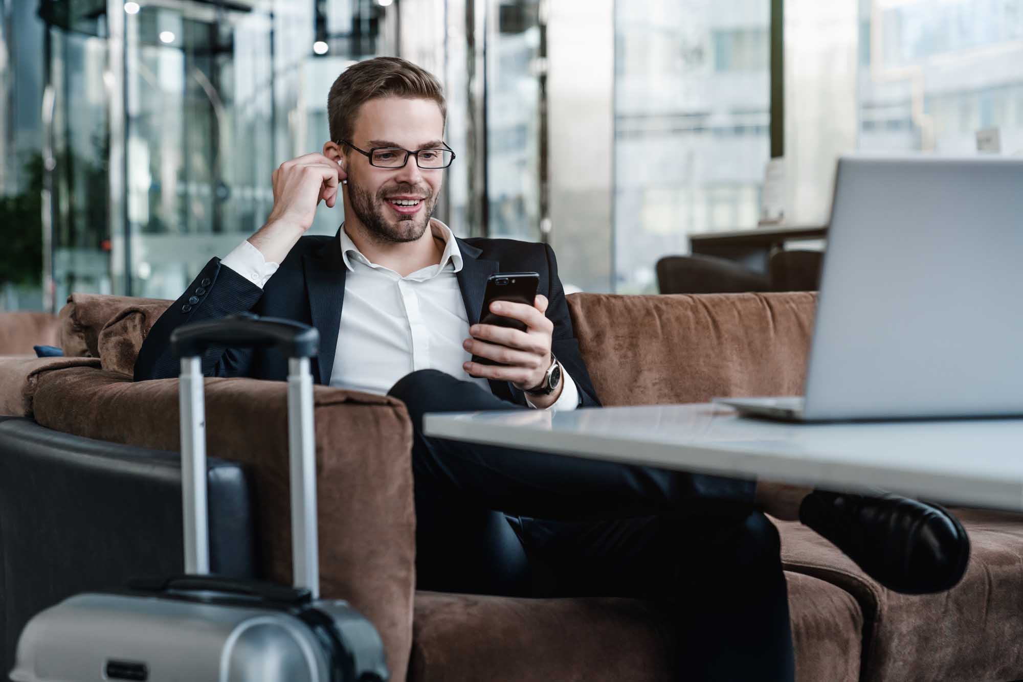 Business Traveler in Modern Airport Lounge Experienced travel advisor working between flights in an airport lounge